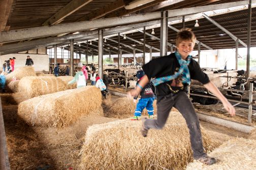 Kinder spielen im Heu