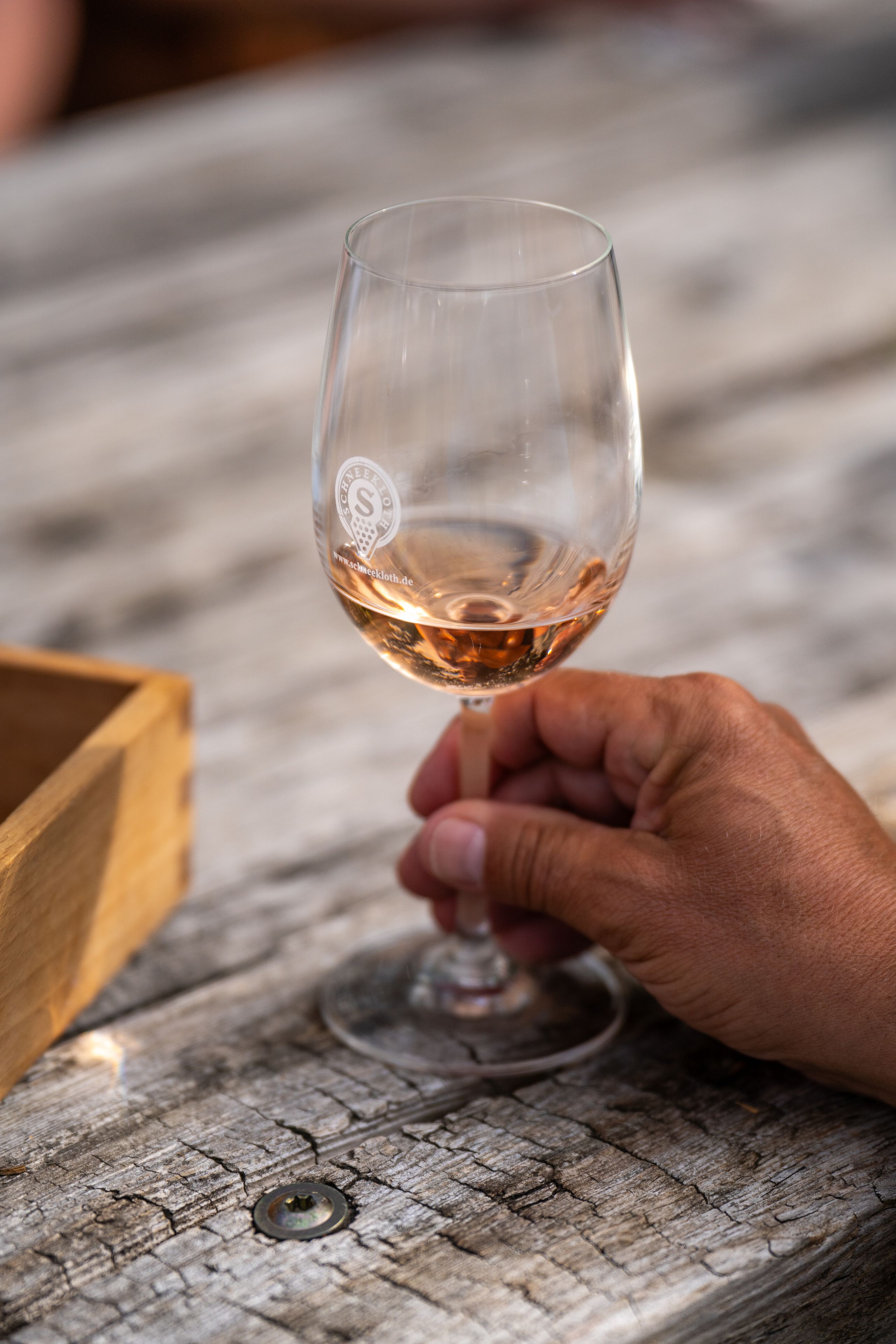Ein Glas Roséwein wird genussvoll gehalten. 