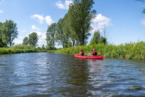 Kanufahrer schippern mit ihrem Kanu auf dem Fluss daher. 