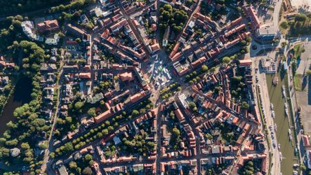 Luftaufnahme von Glückstadt zeigt das sternförmige Straßennetz und den Hafen. Die Stadt ist von grünen Bäumen und Wasser umgeben.