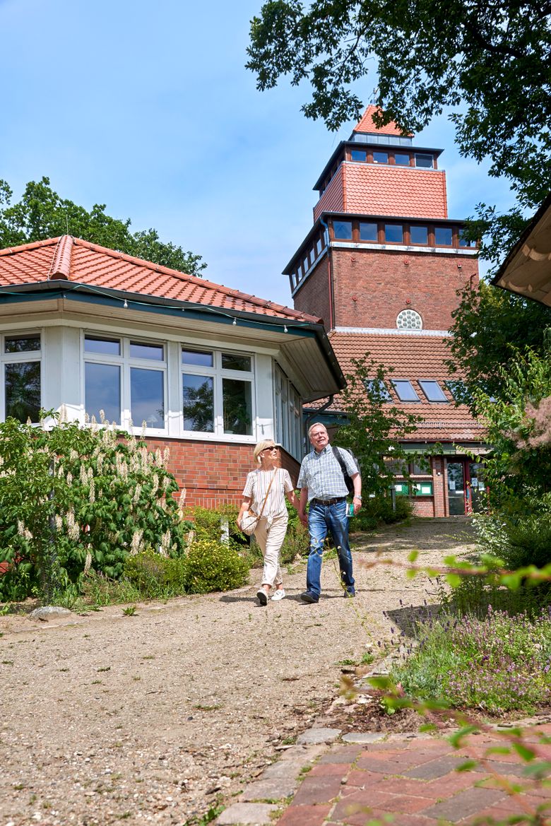 Ein Paar geht an dem Waldmuseum Burg entlang spazieren.