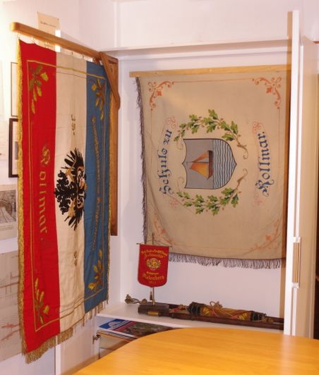 Historische Fahnen und Banner in einer Vitrine.